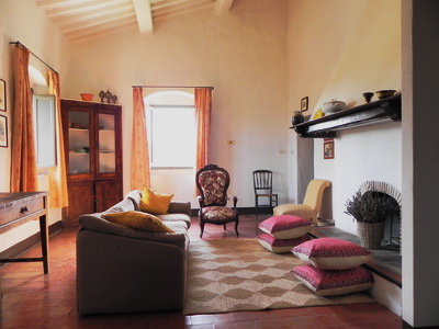 salon avec cheminée de la ferme Cinatto à Saturnia en Toscana